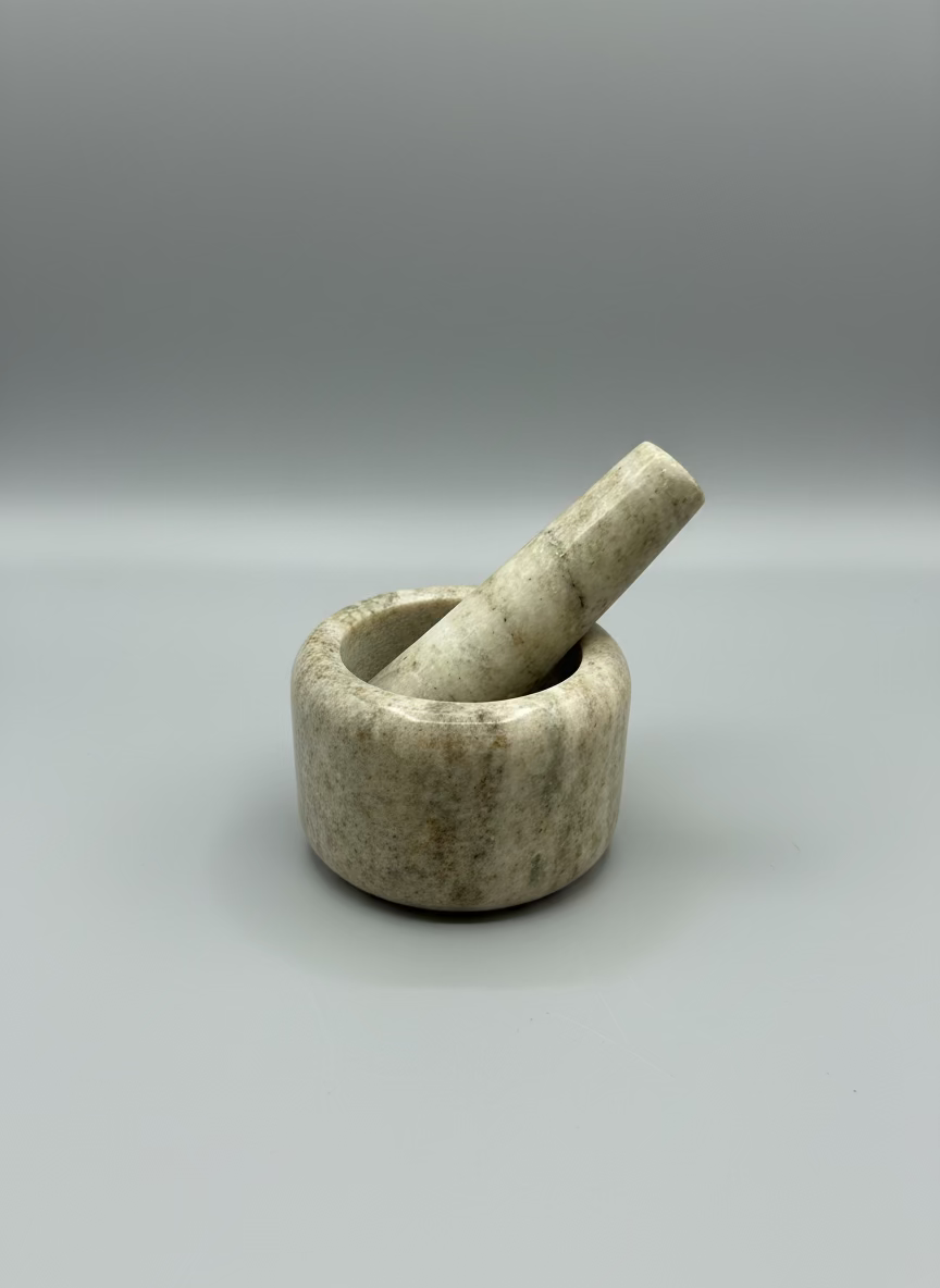 Stone mortar and pestle on a metallic surface