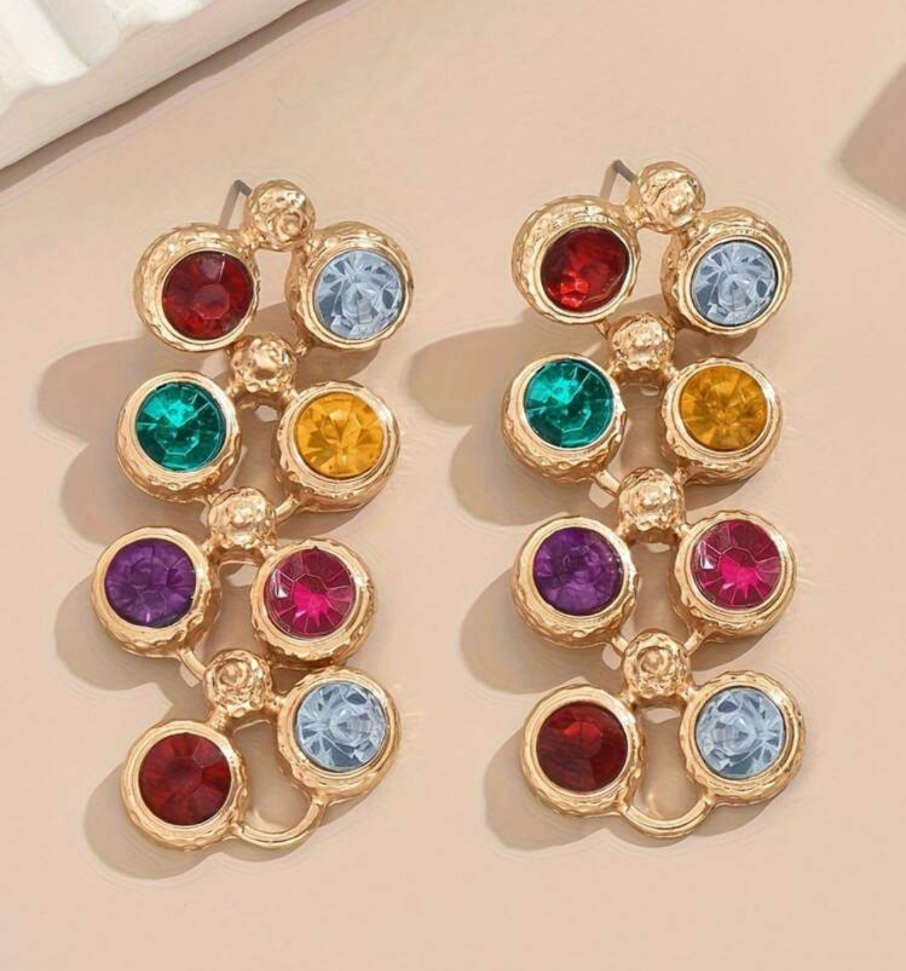 Multicolored gemstone earrings on a beige background