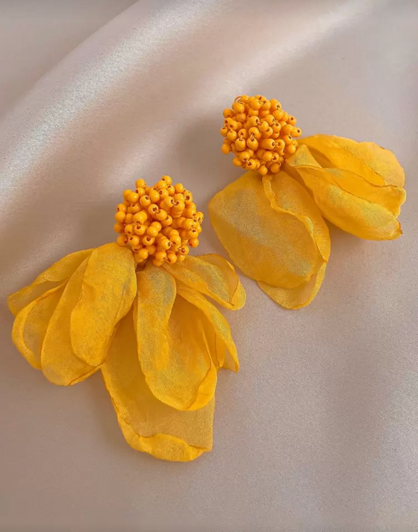 Yellow floral earrings on a light gray background