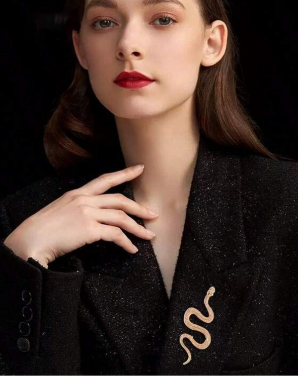 Woman wearing a black outfit with a gold emblem, promotional text at the bottom.