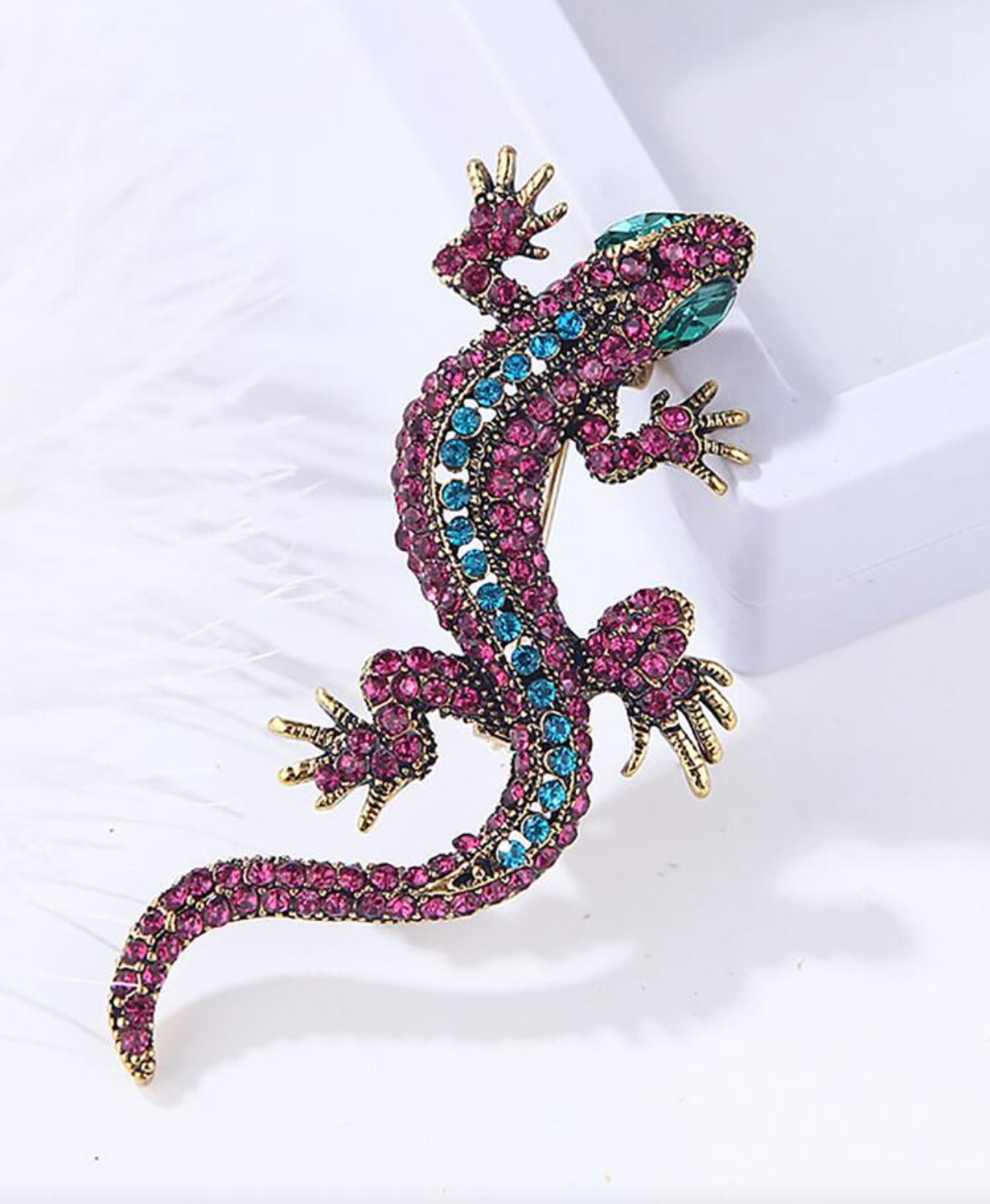 Decorative lizard figurine with gemstone accents on a white background