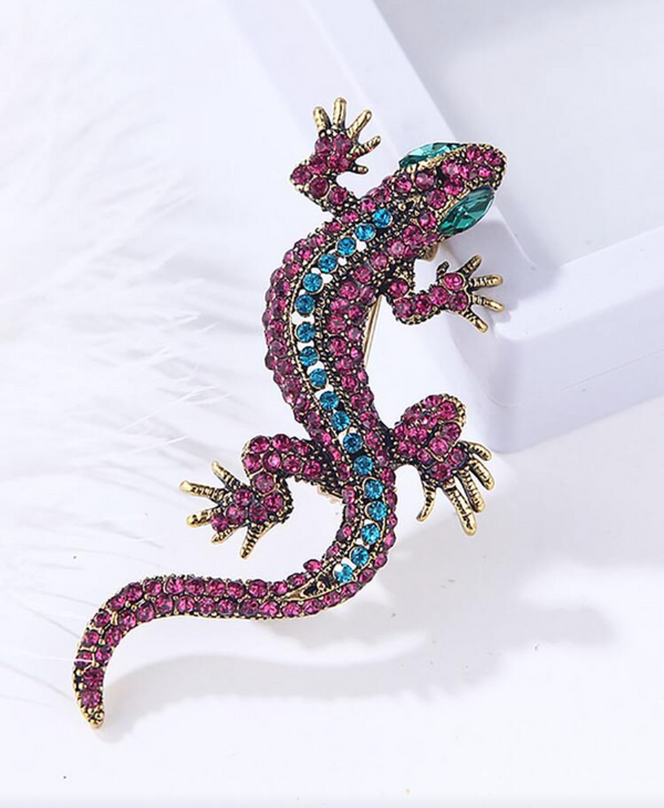 Decorative lizard figurine with gemstone accents on a white background