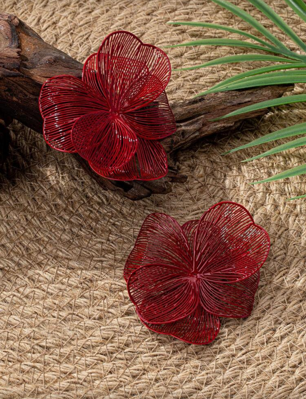 Red floral earrings on a textured surface 