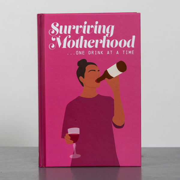 Book titled 'Surviving Motherhood... One Drink at a Time' with a pink cover and illustration of a woman drinking.